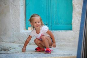 petite belle fille se promène dans les vieilles rues du village grec emporio photo