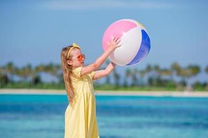 petite fille adorable jouant avec un ballon d'air en plein air en vacances photo