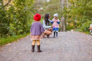 jeune mère avec ses adorables filles heureuses s'amusant en plein air dans le parc d'automne photo