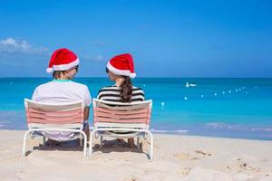 couple heureux portant un bonnet de noel à la plage des caraïbes photo