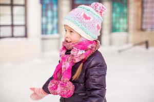 adorable petite fille heureuse patinant sur la patinoire photo