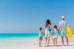 belle famille heureuse sur la plage blanche s'amusant photo