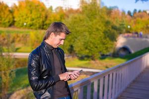 jeune homme avec un téléphone dans le parc photo