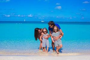 famille heureuse de quatre personnes en vacances à la plage photo