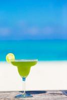 savoureux cocktail vert sur la plage blanche tropicale photo