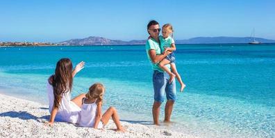 famille de quatre personnes s'amusant pendant leurs vacances tropicales photo