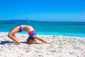 adorable petite fille sportive sur la plage tropicale blanche photo