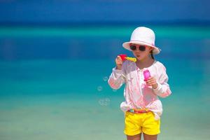 adorable petite fille faisant des bulles de savon pendant les vacances d'été photo