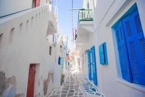 les rues étroites de l'île grecque avec des balcons bleus, des escaliers et des fleurs. belle architecture extérieure de bâtiment de style cycladique. photo
