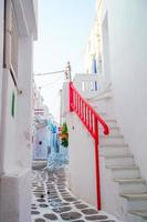 les rues étroites de l'île grecque avec balcons, escaliers et fleurs. belle architecture extérieure de bâtiment de style cycladique.