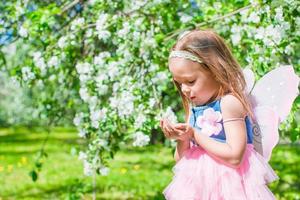 adorable petite fille dans un jardin de pommiers en fleurs photo