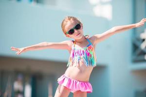 portrait d'une adorable petite fille souriante en vacances à la plage photo