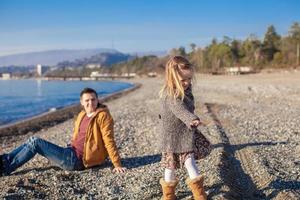 jeune père et petite fille à la plage par une journée d'hiver ensoleillée photo