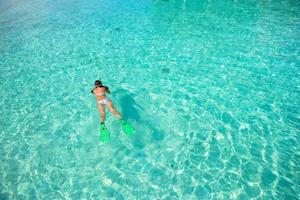 jeune fille plongée en apnée dans l'eau tropicale en vacances photo