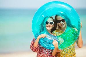 les petites filles drôles et heureuses s'amusent beaucoup sur la plage tropicale en jouant ensemble. photo