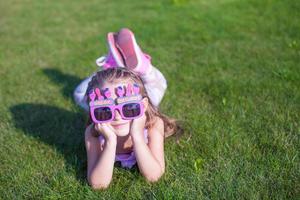 adorable petite fille dans des verres de joyeux anniversaire souriant en plein air photo