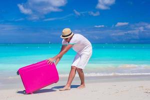 jeune voyageur avec ses bagages sur une plage tropicale photo