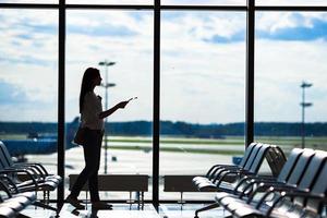 silhouette de femme dans un salon d'aéroport en attente d'avions de vol photo