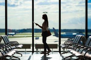 silhouette de femme dans un salon d'aéroport en attente d'avions de vol photo