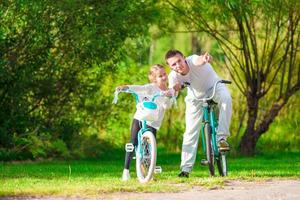 jeune famille active faisant du vélo le jour de l'été photo