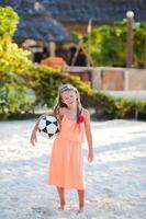 petite fille adorable jouant au volley-ball sur la plage avec ballon photo