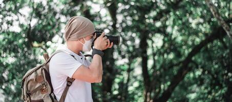 homme voyageur asiatique avec sac à dos prenant une photo dans le parc