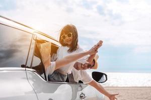 les petites filles voyageant en voiture heureuses profitent des vacances et de la détente. voyage en voiture à hayon conduite voyage en voiture vacances d'été en famille en voiture au coucher du soleil, ensemble obtenir l'atmosphère aller à destination photo