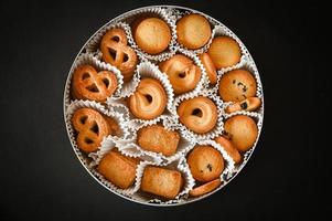 boîte à biscuits avec biscuits au beurre danois sur fond de tableau noir, vue de dessus photo