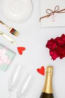 concept de la saint-valentin, champagne et rose sur la table avec couverts en verre et coffret cadeau pour le dîner photo
