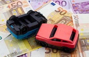 accident de deux voitures isolées sur fond de billets en euros. notion d'accident de voiture. photo