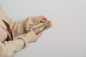 main de femme tenant la pile de billets de banque en yen japonais. mille yens d'argent. trésorerie du japon, impôt, économie de récession, inflation, investissement, finances et concepts de paiement d'achat photo