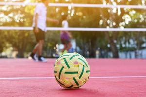 balle sepak takraw sur le sol rouge du terrain extérieur, arrière-plan flou, activité récréative et sports de plein air dans le concept des pays d'asie du sud-est. photo