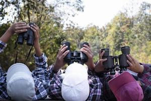 les garçons asiatiques utilisent des jumelles pour observer les oiseaux dans la forêt tropicale pendant le camp d'été, idée pour apprendre les créatures et les animaux sauvages et les insectes en dehors de la salle de classe. photo