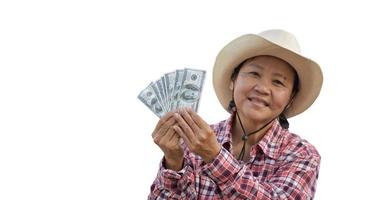une femme asiatique âgée isolée nous tient des billets de banque en dollars à la main avec un beau sourire sur son visage joyeusement avec des chemins de détourage. photo