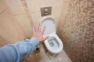 l'homme montre la main d'arrêt dans les toilettes. photo