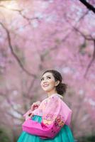 hanbok, la robe coréenne traditionnelle et belle fille asiatique avec sakura photo