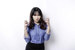 un portrait d'une femme asiatique portant une chemise bleue isolée par un fond blanc a l'air déprimé photo