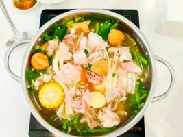 vue de dessus marmite japonaise sur tableau blanc. le shabu est une sorte de fondue japonaise semblable au sukiyaki par la cuisson, ces objets vont être plongés dans la soupe puis mangés en les trempant dans la sauce. photo