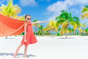 petite fille mignonne jouant au super-héros sur une plage tropicale photo