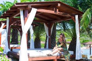 jeune belle femme se reposant sur un lit de plage pendant des vacances tropicales photo