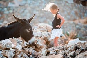 petite fille adorable avec un âne sur mykonos photo