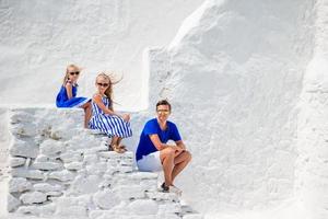 famille de trois personnes dans les escaliers de l'église paraportiani sur l'île de mykonos, en grèce photo