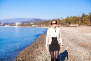 belle jeune femme marchant sur la plage en hiver journée ensoleillée seule photo