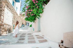 enfant dans la rue du village traditionnel grec typique avec des escaliers blancs sur l'île grecque photo