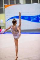 belle petite fille gymnaste active avec sa performance sur le tapis photo