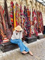 ancienne boutique de tapis turcs traditionnels dans la maison troglodyte de cappadoce, turquie kapadokya. jeune femme en vacances en turquie photo