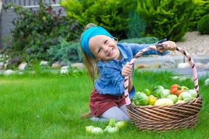 petite fille avec une grande récolte d'automne de tomates dans des paniers photo