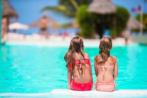 adorables petites filles dans la piscine extérieure pendant les vacances d'été photo