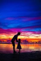 silhouettes père et fille au coucher du soleil sur la plage de boracay, philippines photo