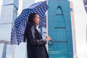 jeunes femmes d'affaires charmantes marchant sous un parapluie un jour de pluie photo